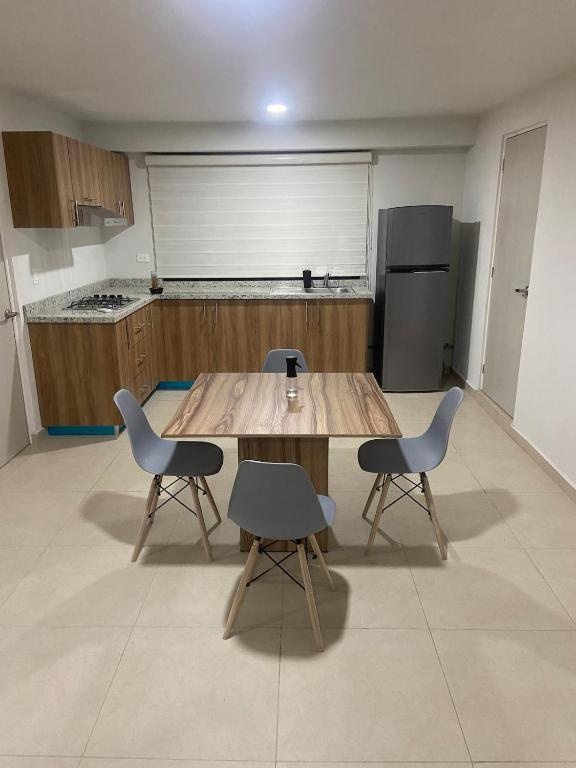 a kitchen with a wooden table and two chairs at Apartment with pool in Culiacán
