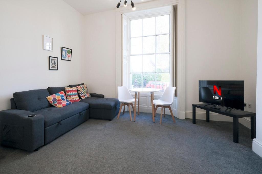 una sala de estar con un sofá y una mesa en 1 Bedroom Apartment, Free Parking, WiFi, en Gloucester