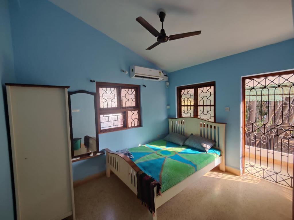 a bedroom with a bed and a ceiling fan at Mati Mogra in Calangute