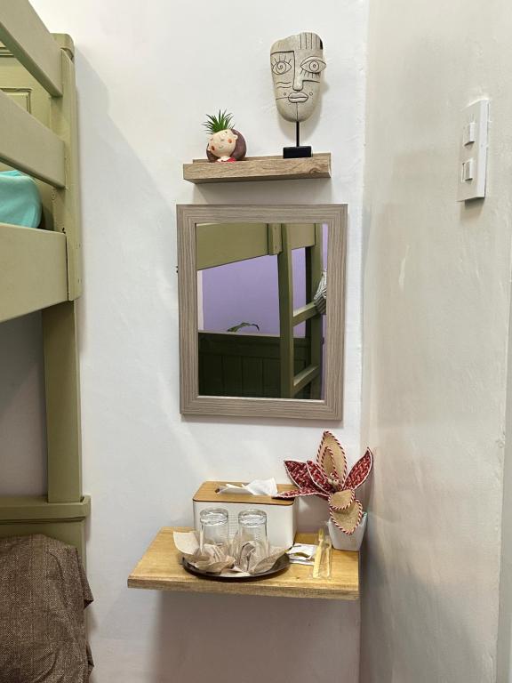 a small table with a mirror and glasses on it at The ComfyNook Hostel 