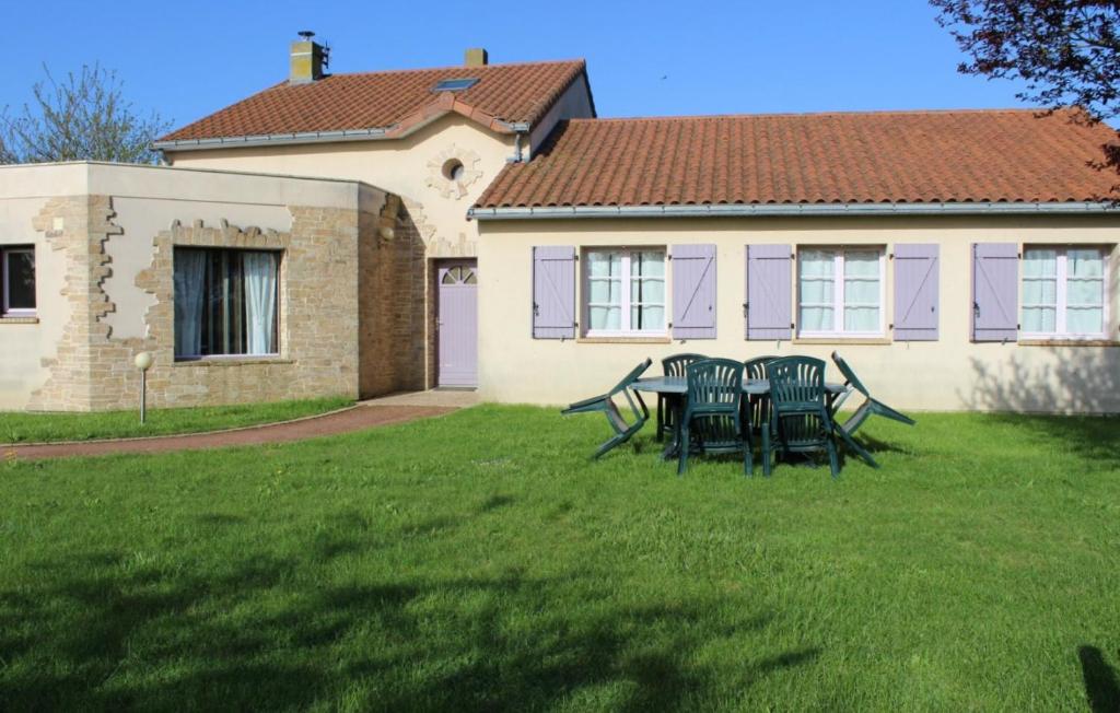 朗德蒙特Gîte Isatis的房子前面的一张桌子和几把椅子