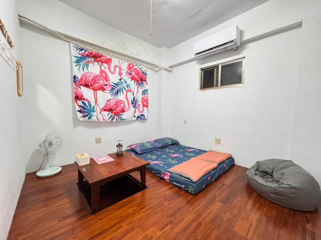 ein Zimmer mit einem Bett und einem Tisch darin in der Unterkunft 蘭嶼喜樂家 Joy House Lanyu in Lanyu