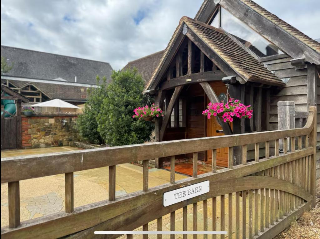 a wooden house with a sign on a fence at The barn Alexandra mews in Heathfield