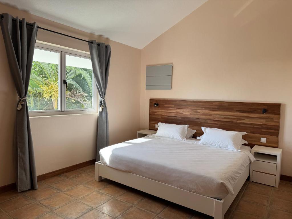 a bedroom with a large bed and a window at Lakaz Mapou - Magnifiques Appartements rénovés de 3 chambres et 2 salles de bains in Rivière Noire