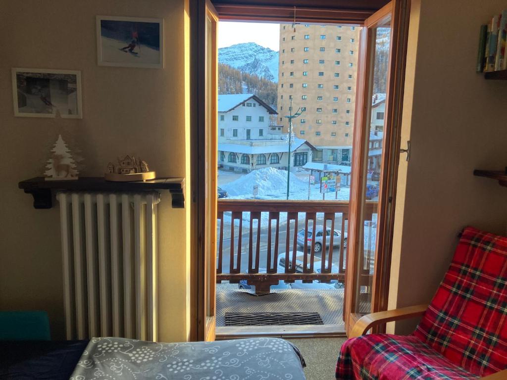 a room with a door to a balcony with a view at mountain summit sestriere in Sestriere