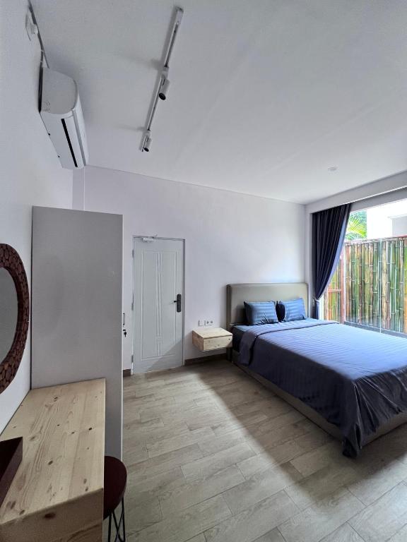 ein Schlafzimmer mit einem Bett und einem großen Fenster in der Unterkunft The Inside House Medewi in Airsatang