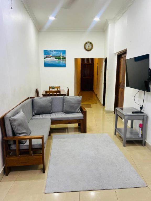 a living room with a couch and a tv at Vuga Town House in Zanzibar City