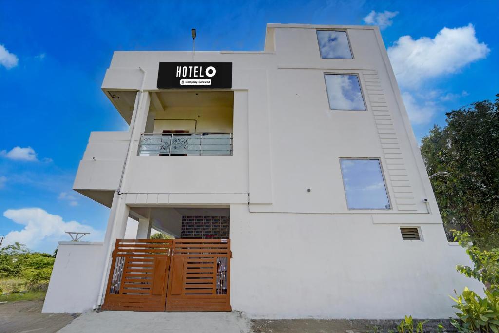 a white building with a sign on it at Hotel O Muthalipalayam Bus Stand Coimbatore Formerly Haven Stays in Irugūr