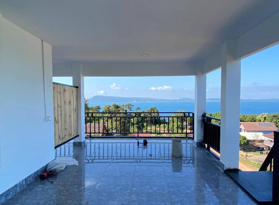 a room with a balcony with a view of the ocean at Big Head Bungalows in Koh Rong Sanloem