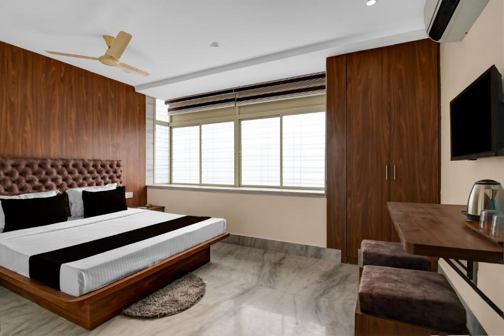 a bedroom with a bed and a desk and a television at Hotel O Netaji Metro Station Kolkata Formerly Mahamaya Step Inn in Thakurpukur
