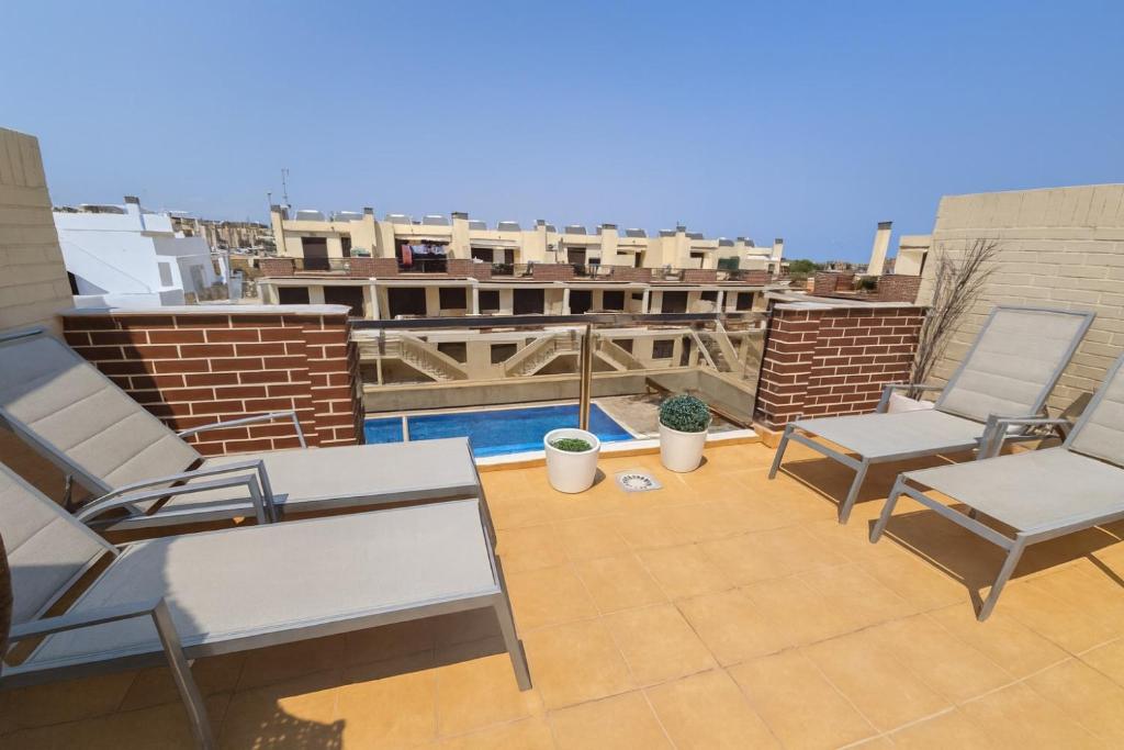 a patio with two chairs and a pool on a roof at 3 bedroom, two-level, morden apartment in Orihuela Costa