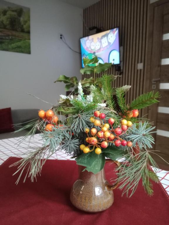 Un albero di Natale in un vaso su un tavolo di Całoroczny Apartament u Grzegorza a Lidzbark