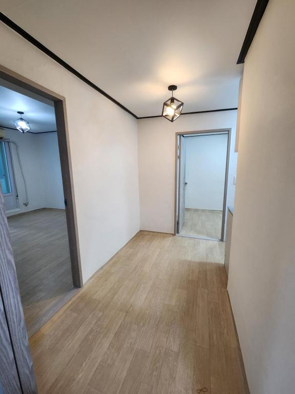una stanza vuota con pareti bianche e pavimenti in legno di 포항 파티룸 숙박깔끔 a Pohang