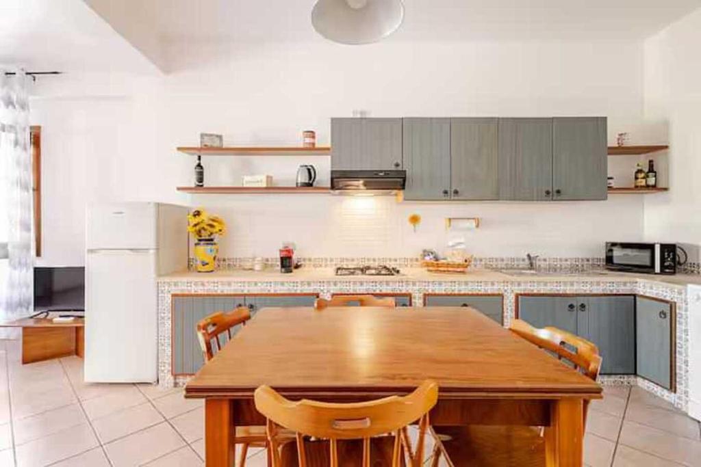 duża kuchnia z drewnianym stołem i krzesłami w obiekcie Villa Uzzo by Sicily Travelling Villas w mieście Scopello