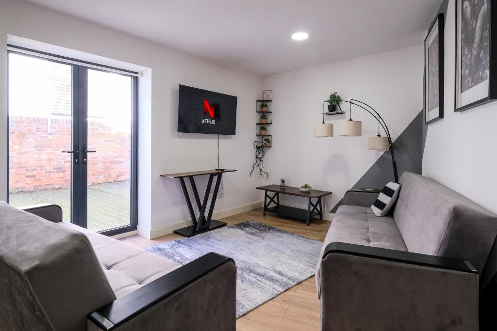 una sala de estar con un sofá y una mesa en 2 Bedroom Spacious Apartment, Free Parking, WiFi, en Gloucester