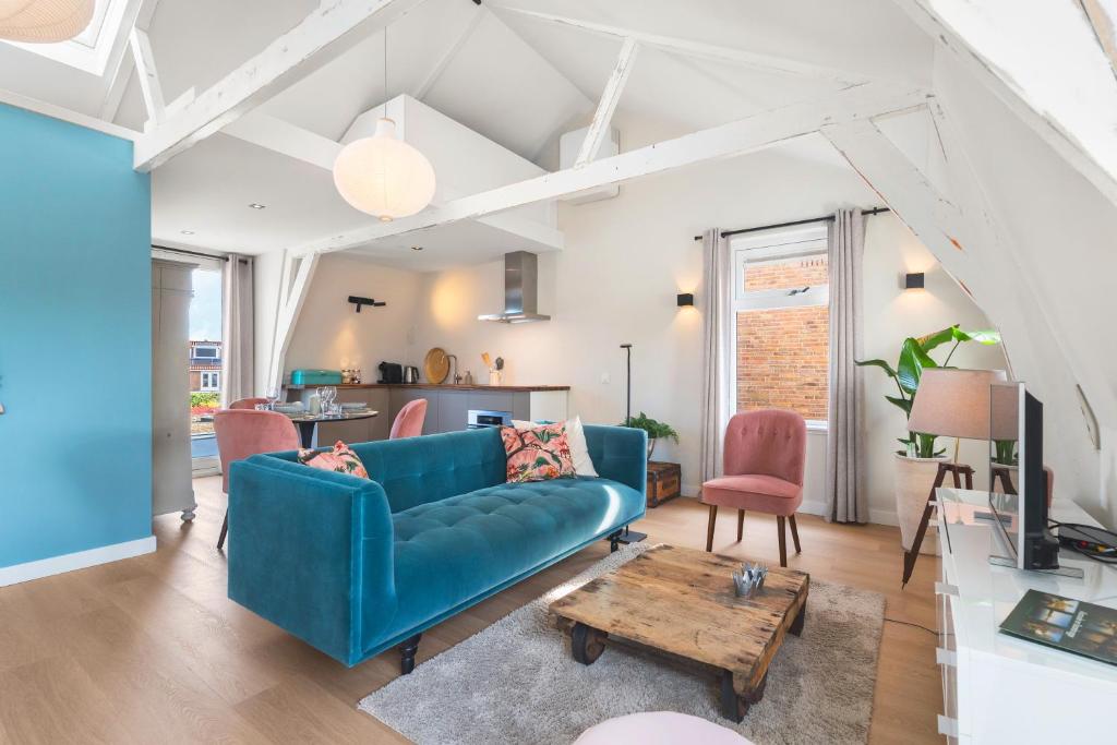een woonkamer met een blauwe bank en een tafel bij Abcoude city center in Abcoude