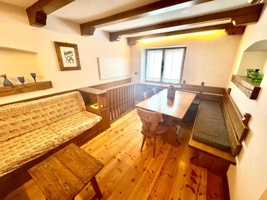 Cozy Apartment - Alverà في كورتينا دامبيتزو: غرفة معيشة مع أريكة وطاولة خشبية