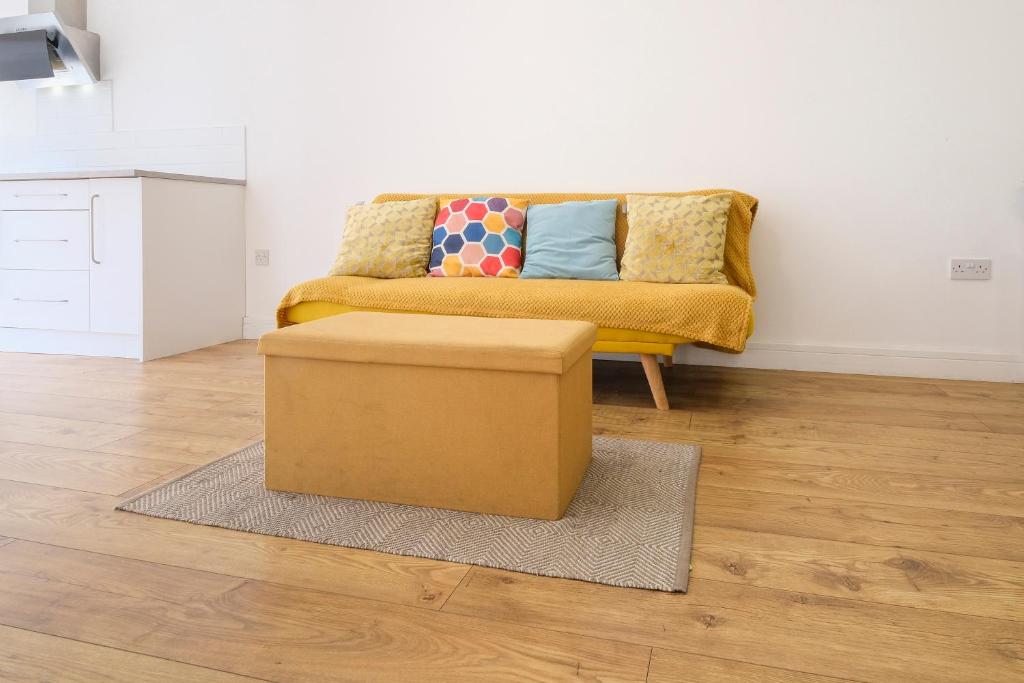 sala de estar con sofá amarillo y reposapiés en Modern 2 Bedroom Apartment, Free Parking, WiFi, en Gloucester