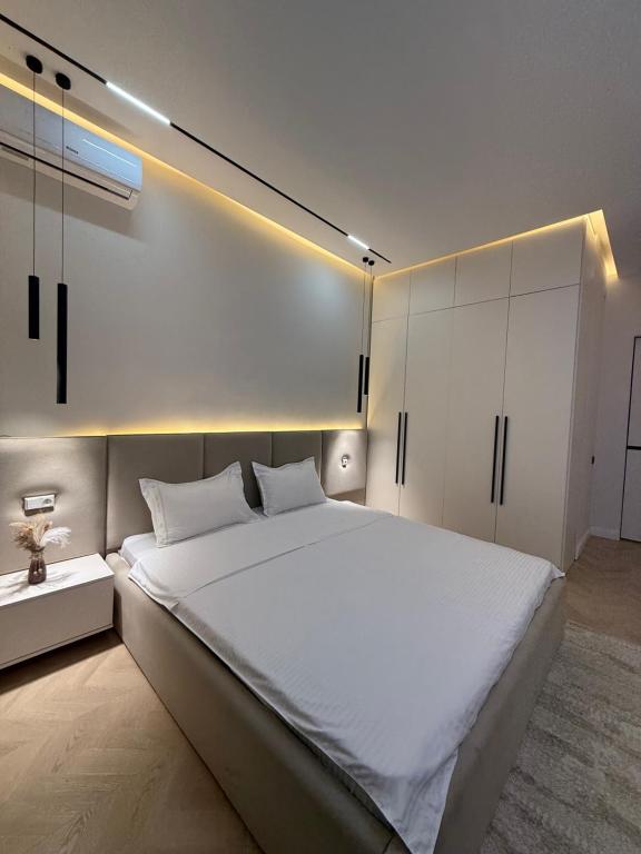 een slaapkamer met een groot wit bed en witte kasten bij Altair in Simkent