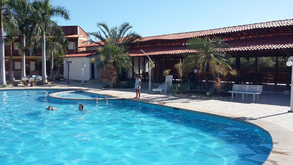 une personne debout dans une piscine dans l'établissement Chalé Porto dos Lençóis, à Barreirinhas
