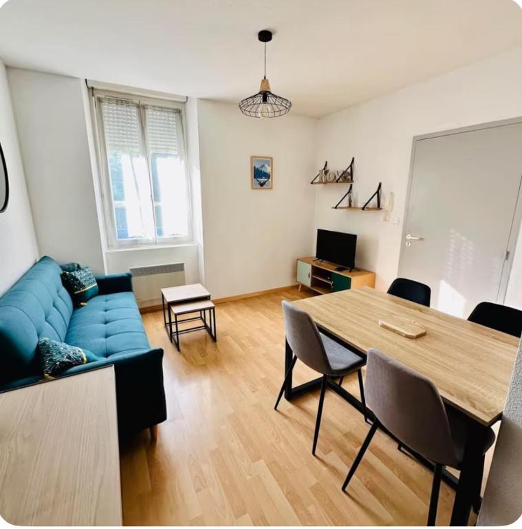 un soggiorno con un divano blu e un tavolo di Appartement - Mon Cottage ad Argelès-Gazost