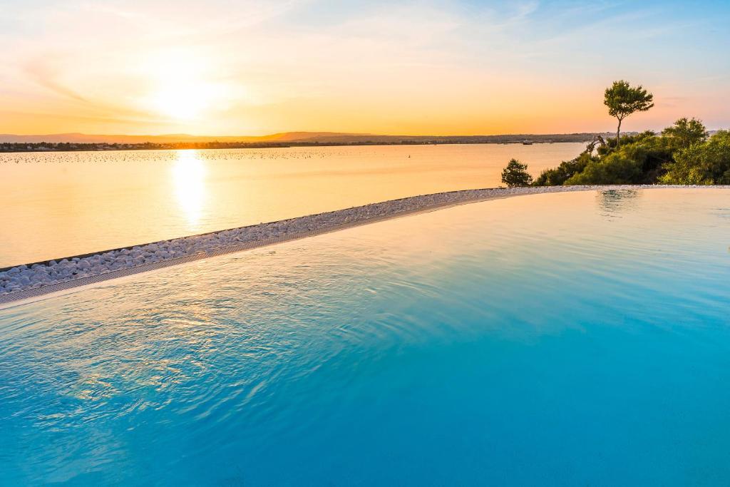 a swimming pool with a view of a body of water at Artemare in Plemmirio