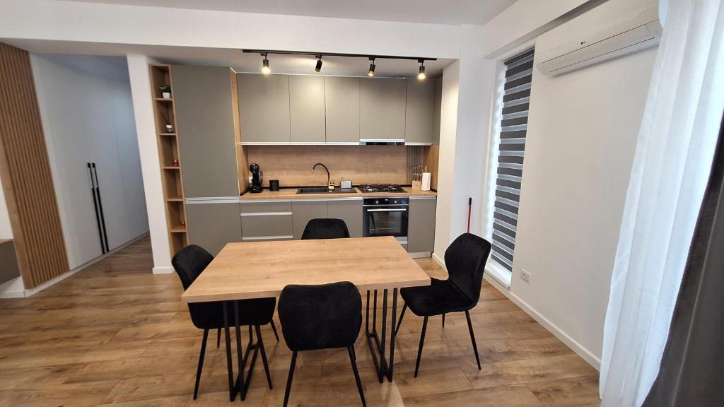een keuken met een houten tafel en zwarte stoelen bij Sara Apartament in Craiova