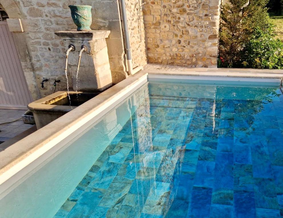 a swimming pool with a water fountain at Gites L INSTANT PRESENT CHEZ LO in Visan