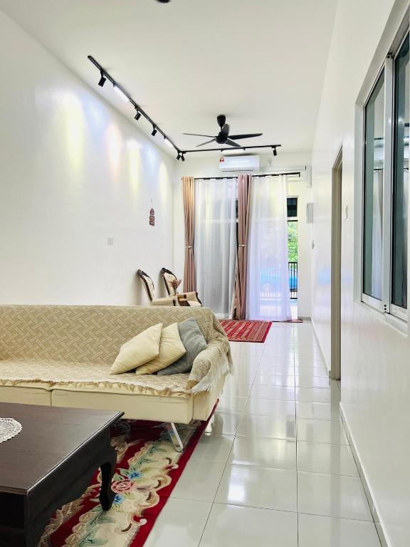 a living room with a couch and a ceiling fan at Inap Indah in Kuantan
