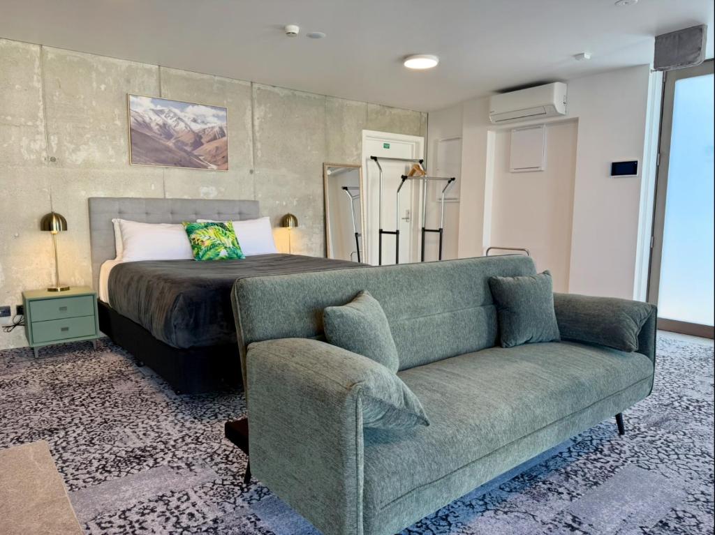 オークランドにあるArluxiaのベッドルーム1室(ベッド1台、ソファ1台、ベッド1台付)