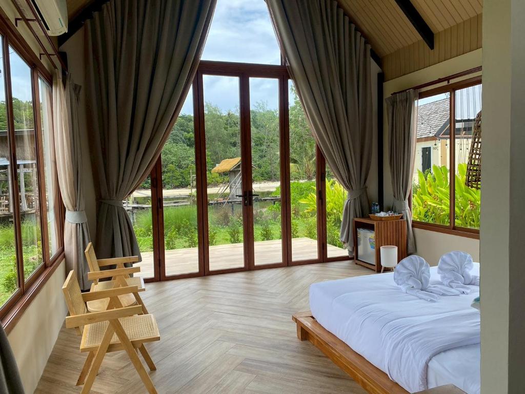 a bedroom with a bed and a large window at Moana Resort Koh Kood in Ban Lak Uan