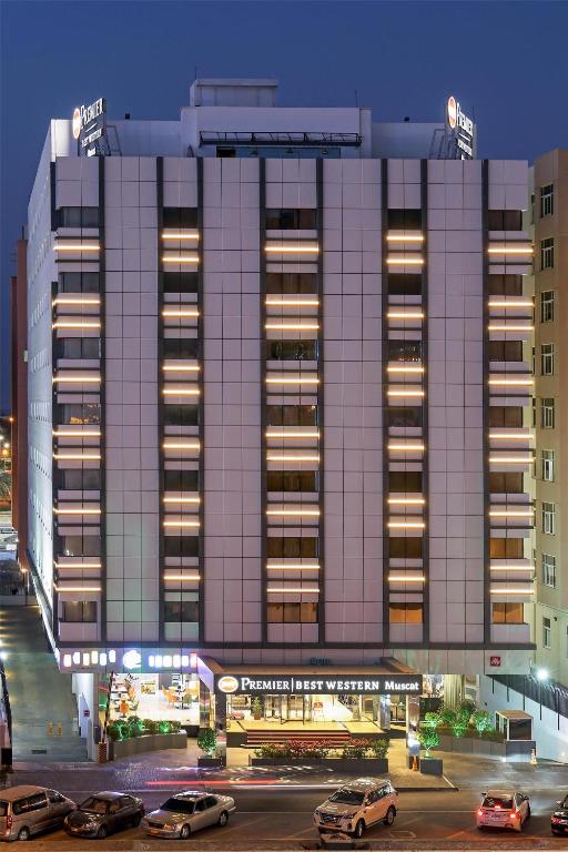 a large building with cars parked in front of it at Best Western Premier Muscat in Muscat