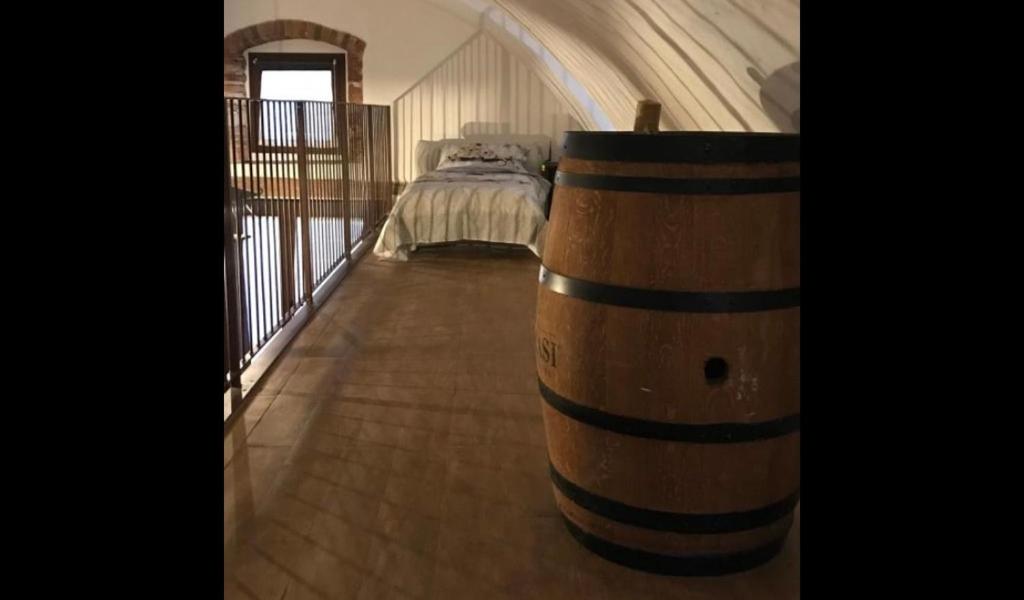 La Cantinetta في سان بيترو في كاريانو: برميل خشبي كبير في غرفة بها سرير