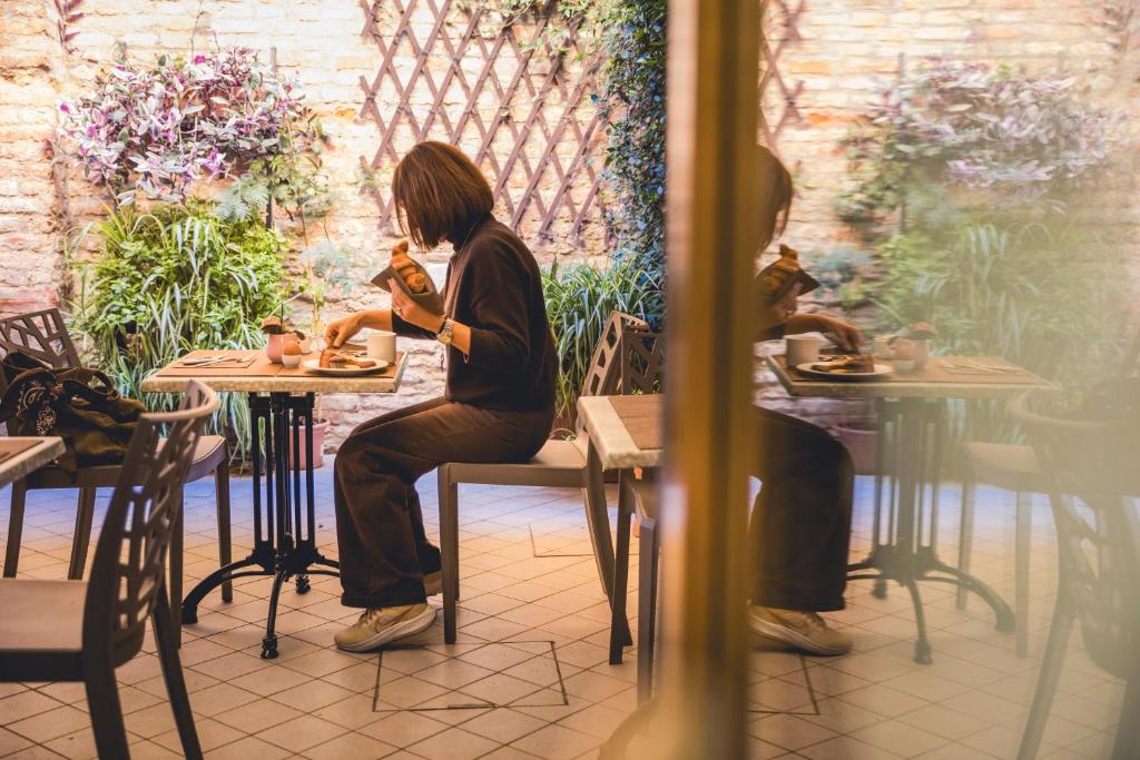 a woman sitting at a table in a restaurant at Locanda Ca' Lucrezia in Venice