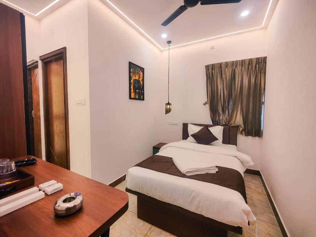 a bedroom with a bed and a wooden table and a desk at Hotel Nova Grande' in Hosūr