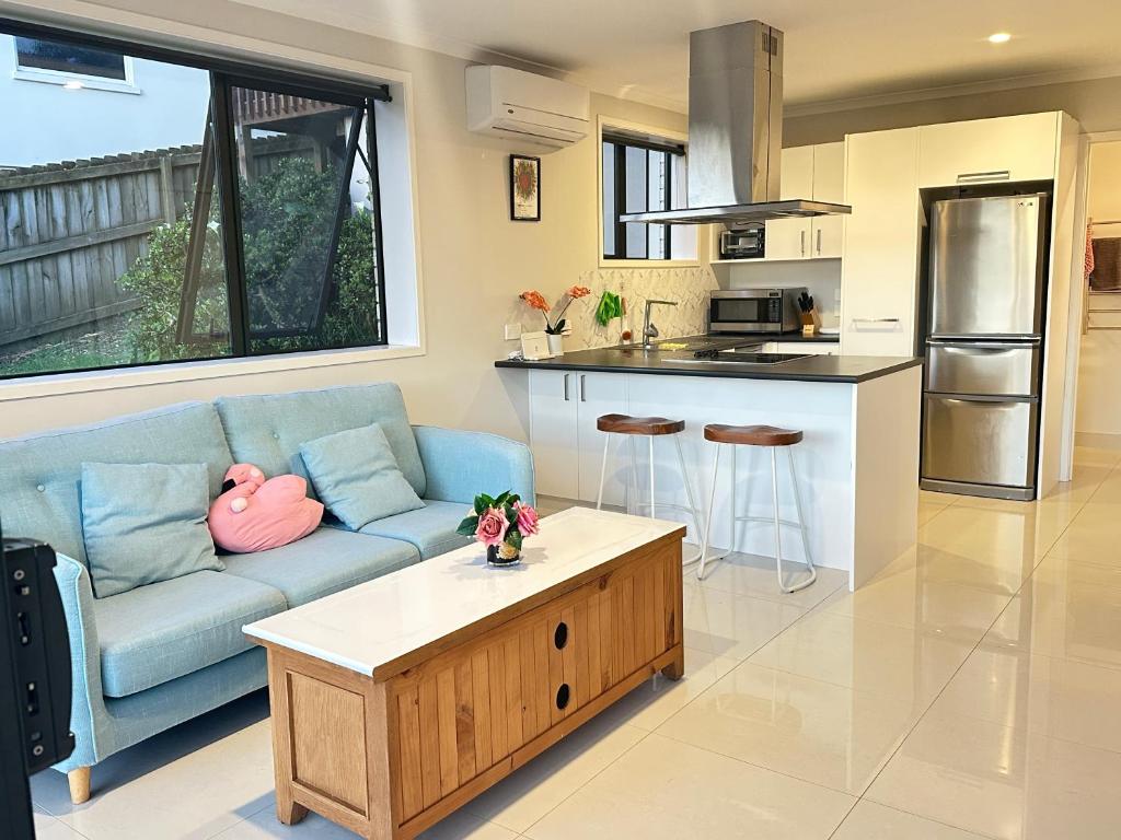 奥克兰Fairview Heights Sunny Deck Retreat的客厅里有一张蓝色的沙发和一张桌子