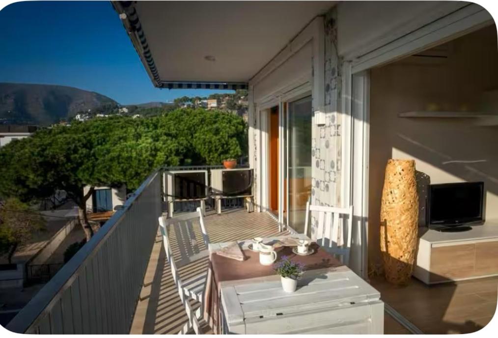 a balcony with a table and a television on a building at Ocean View Sunny Beach Apartment Castelldefels in Castelldefels