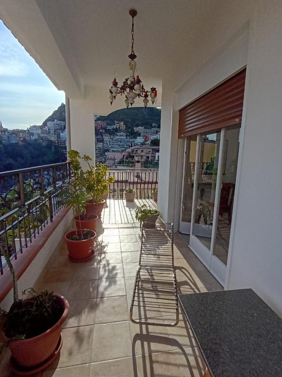 a balcony with potted plants and a chandelier at Horizon Apt in Taormina