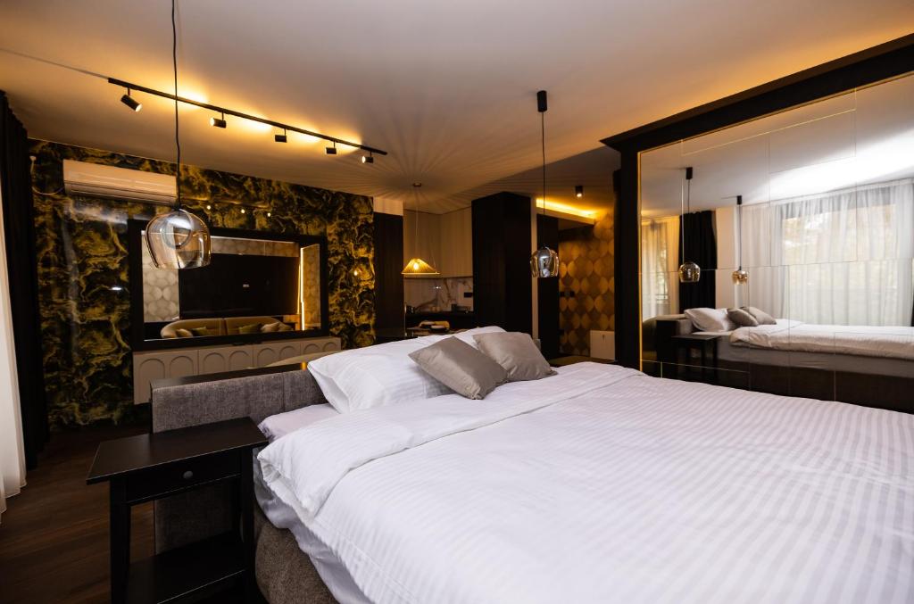 a bedroom with a large white bed and a mirror at Kron in Novi Sad