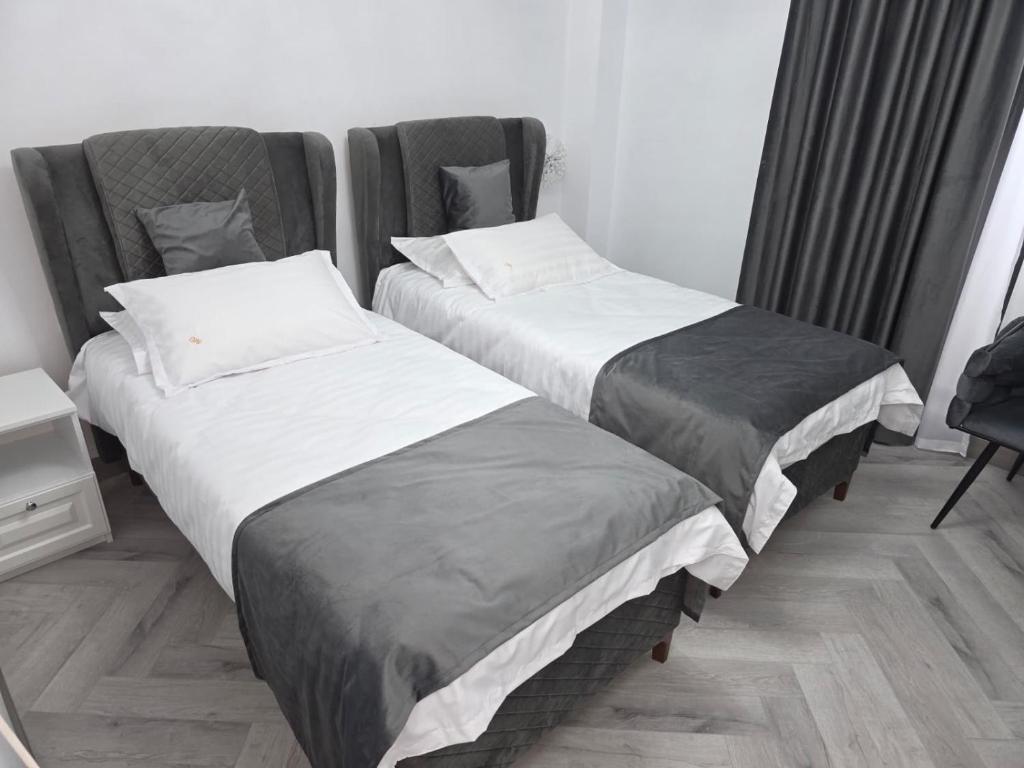 two beds sitting next to each other in a room at Hotel Monica in Bucharest
