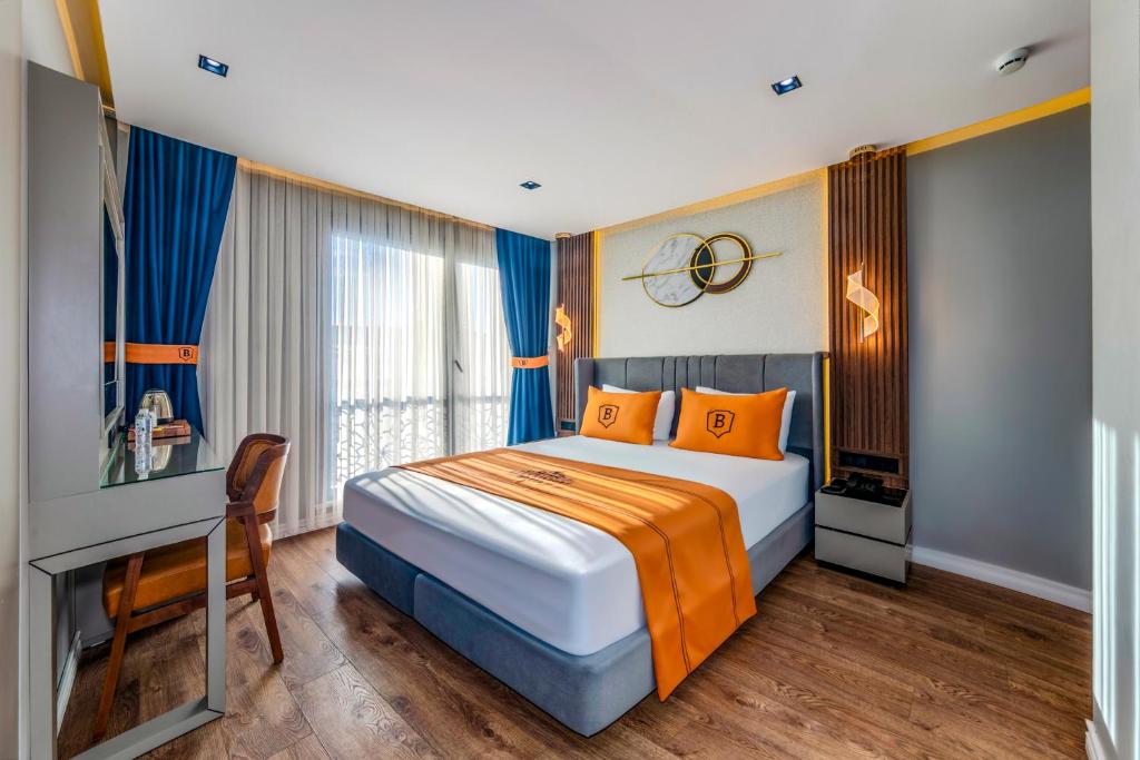 ArnavutköyにあるAirGate Airport Hotelのオレンジの枕が付くベッドが備わるホテルルームです。