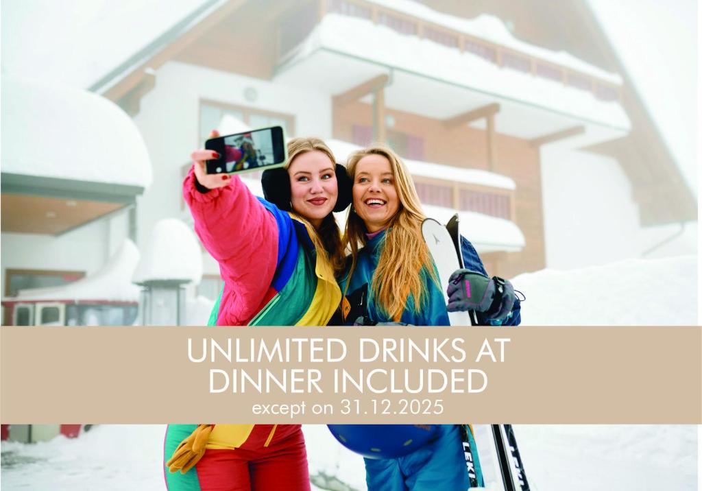 zwei Frauen machen ein Foto vor einem Haus in der Unterkunft Pohorje Village Wellbeing Resort - Wellness & Spa Hotel Bolfenk in Hočko Pohorje