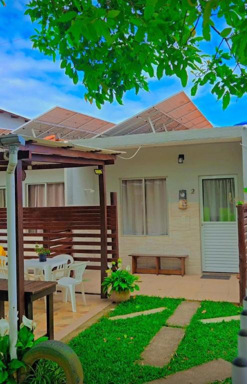 a house with a patio with a table and a bench at Recanto Dos Vargas - Seu refúgio em Floripa com atendimento dos anfitriões in Florianópolis