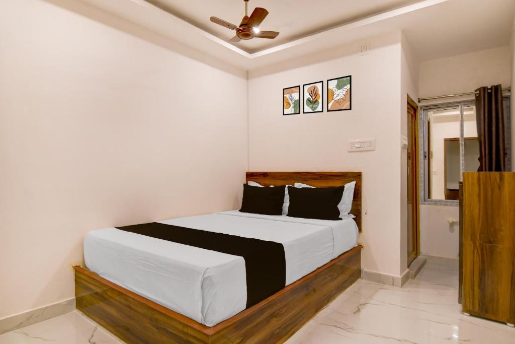 a bedroom with a white bed with a ceiling fan at SPOT ON Night Owl Hotel &guest House in Bārāsat