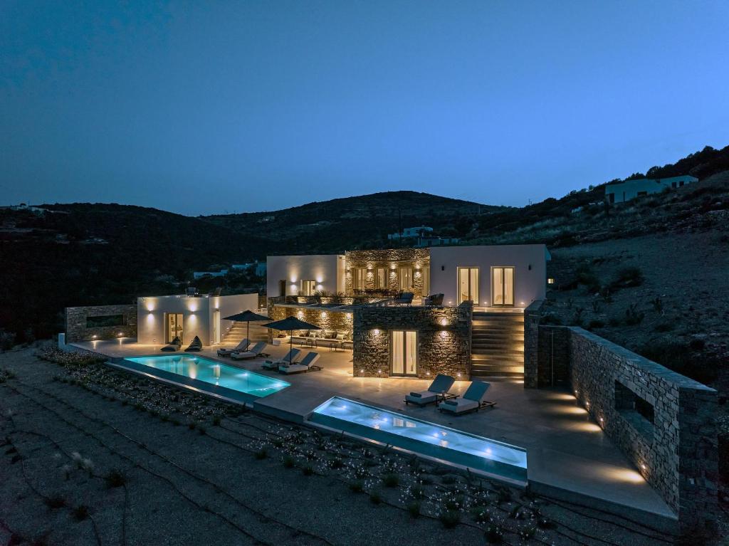a house with a swimming pool at night at Aegean Hestia Luxury Villa of Paros in Kampos Paros