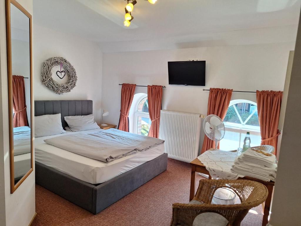 a bedroom with a bed and a table and a tv at Bleckmanns Hof in Werne an der Lippe