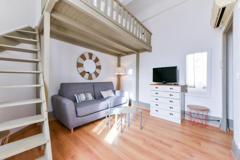 ein Wohnzimmer mit einer Couch und einer Treppe in der Unterkunft Studio élégant pour 4 personnes, à quelques pas de la Croisette in Cannes