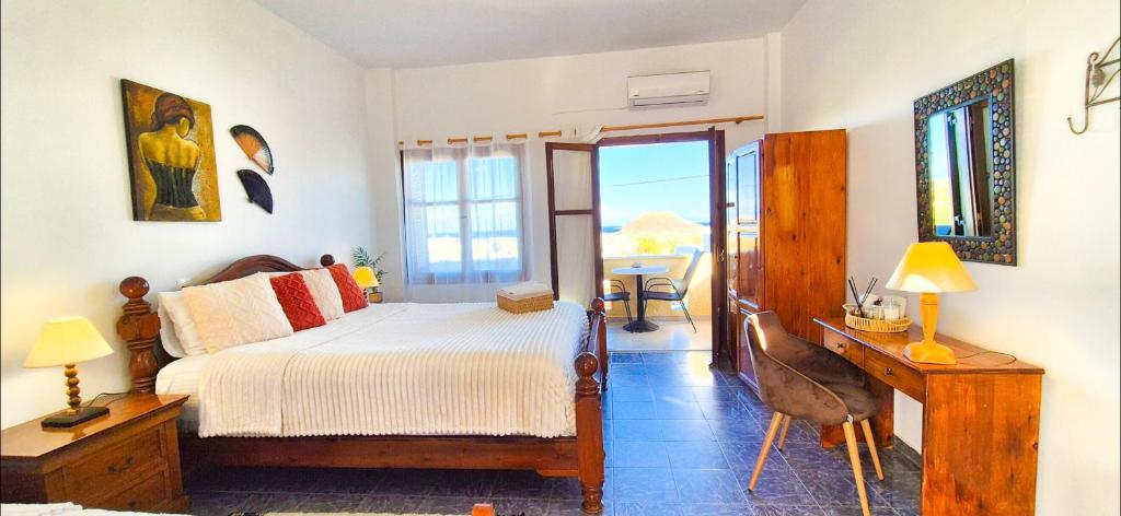Un dormitorio con una cama y un escritorio y un balcón. en Knossos Skynest, en Palaikastro
