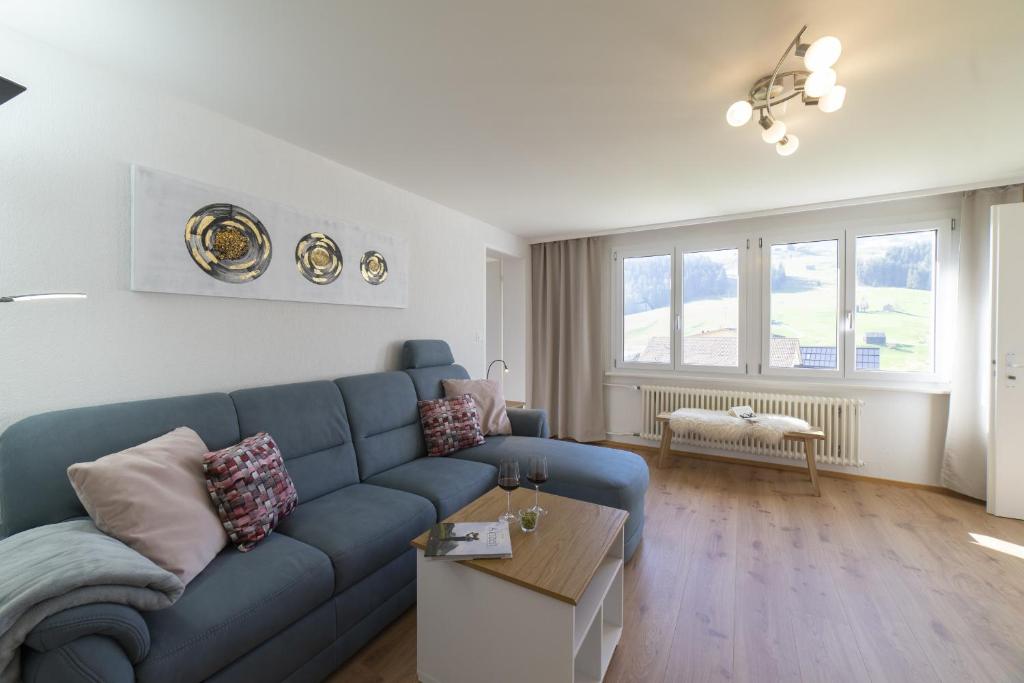 Lisighaus في ويلدهاوس: غرفة معيشة مع أريكة زرقاء وطاولة