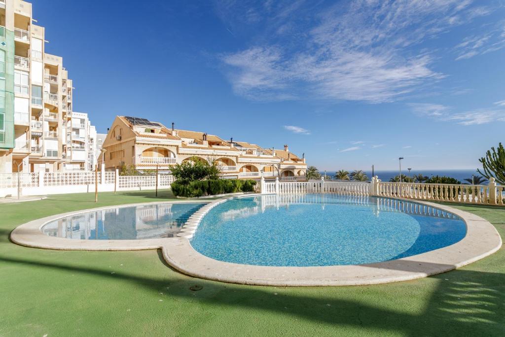 una gran piscina en un patio con un edificio en Los Arenales al Sol, en Arenales del Sol